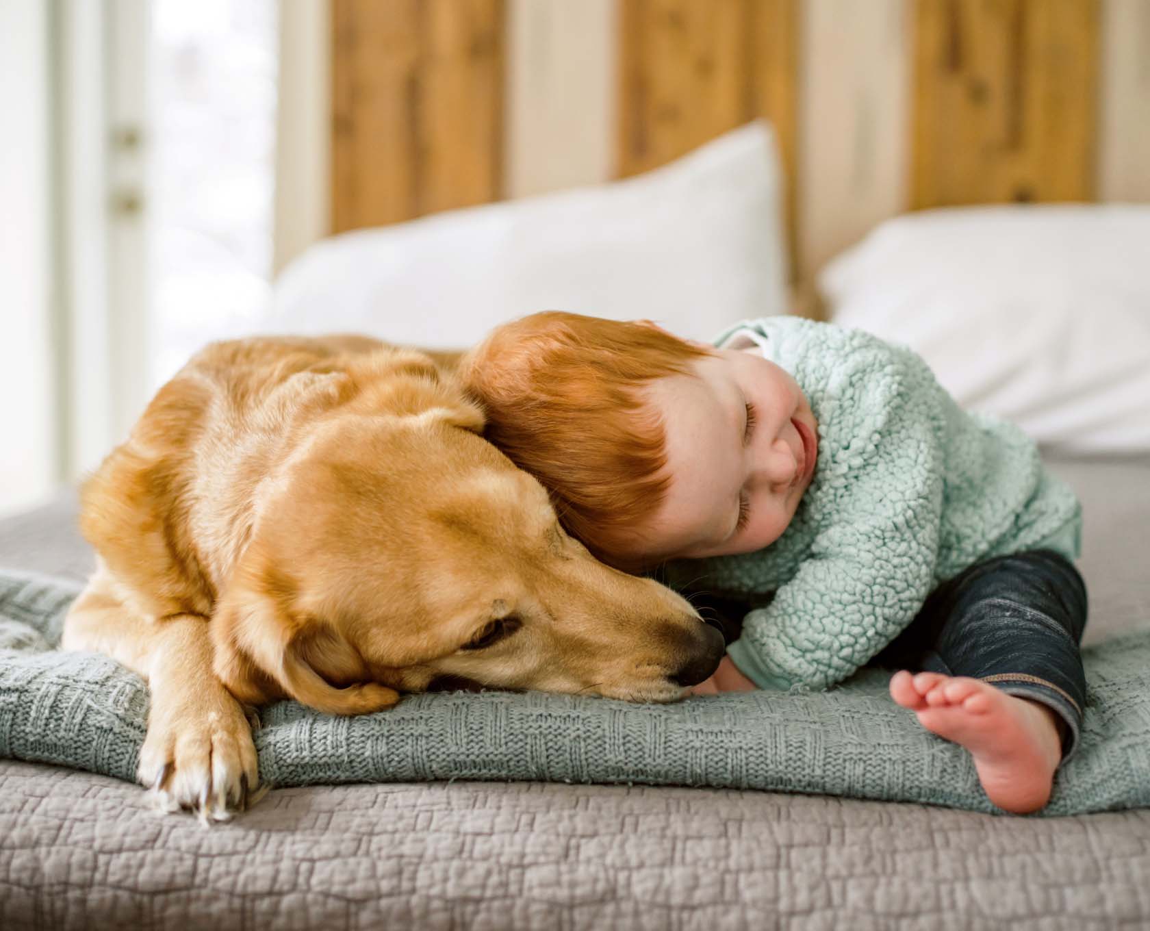 Young child laying with his pet dog