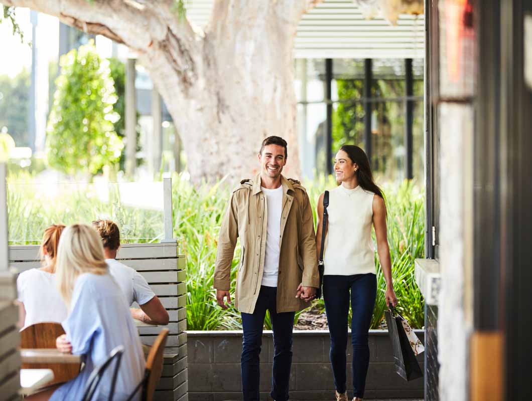 True North, Greenvale young couple walking along restaurant strip.