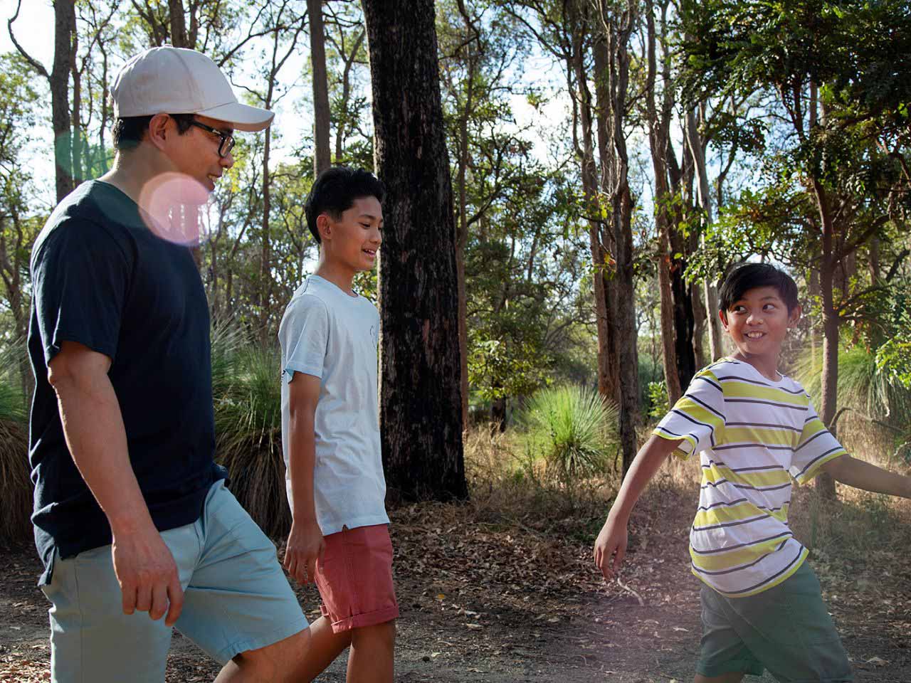 Cassia, Kwinana father walking with two sons amongst the trees