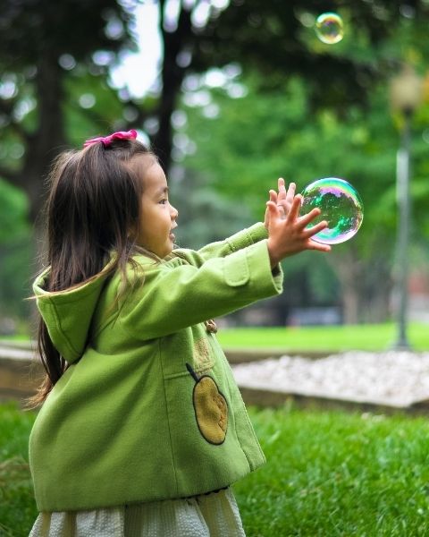 Young child catching a bubble