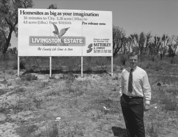 Nigel Satterley AM standing in front of an estate sign
